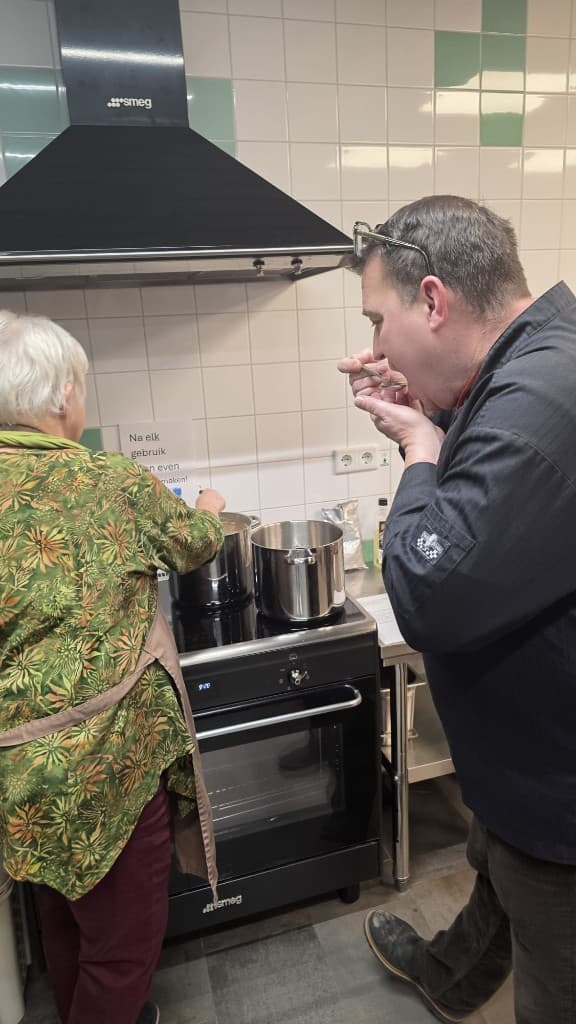 Oosterse avond: deelnemer roert in de pan, chef proeft van de lepel bij de Smeg-fornuis.