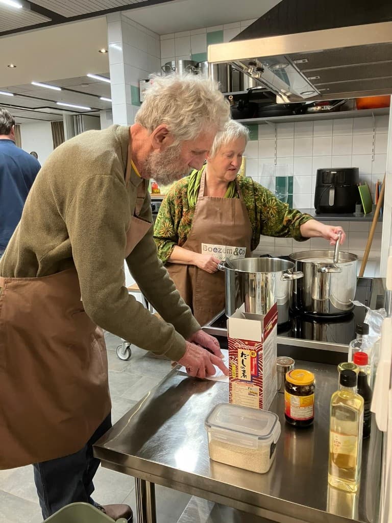 Oosterse avond: twee deelnemers aan het fornuis en recept, met Marutomo Dashi en kruiden op de werkbank.