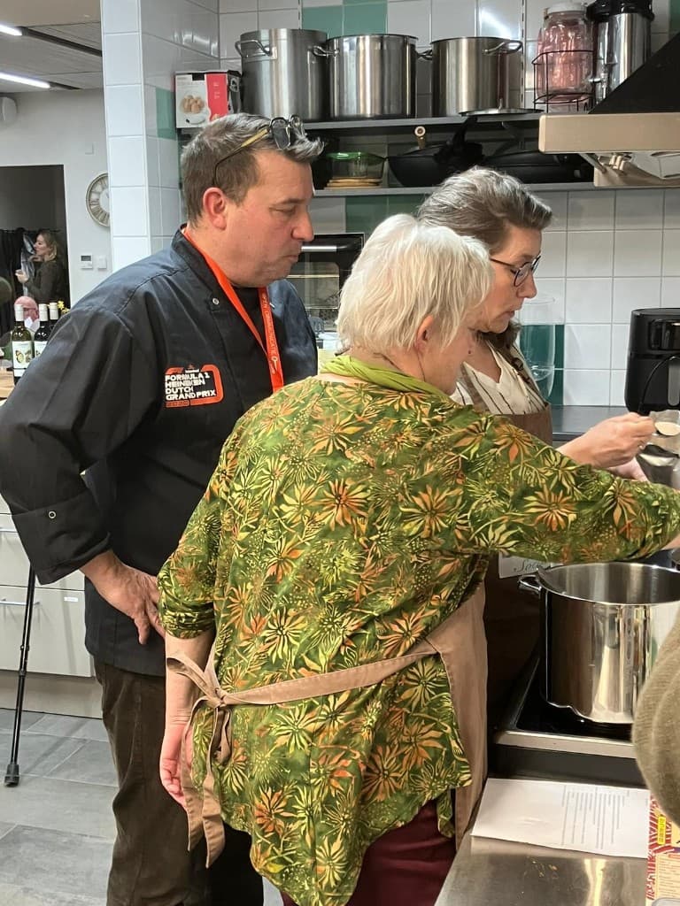 Oosterse avond: chef en deelnemers drukken bezig bij de grote kookpan.
